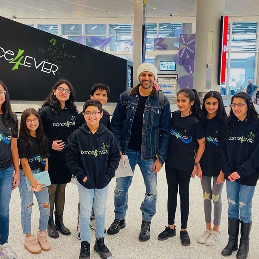 Dance4Ever students with Kartik Aaryan in front of the studio banner