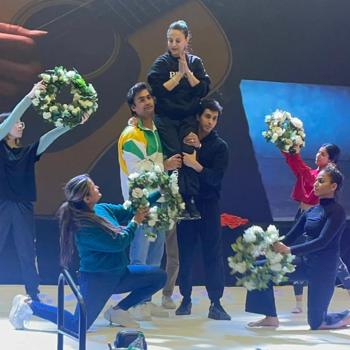 NG Dance Company performing a lift with floral props on stage