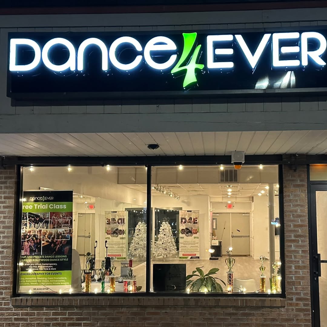 The Dance4Ever studio front at night with the free trial class poster in the window
