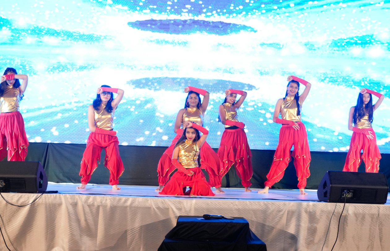 Dance4Ever dancers in colourful Bollywood costumes on the recital stage