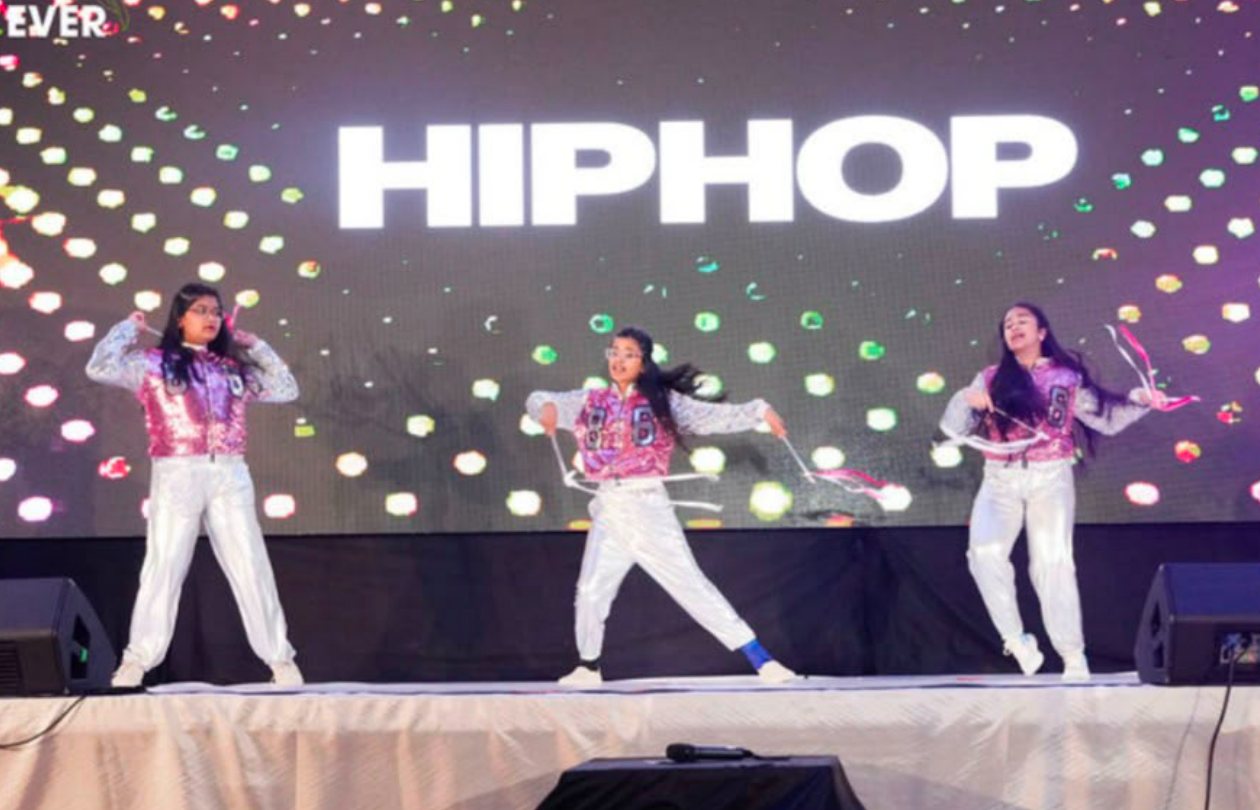 Dance4Ever hip hop batch on stage in front of a Hip Hop backdrop