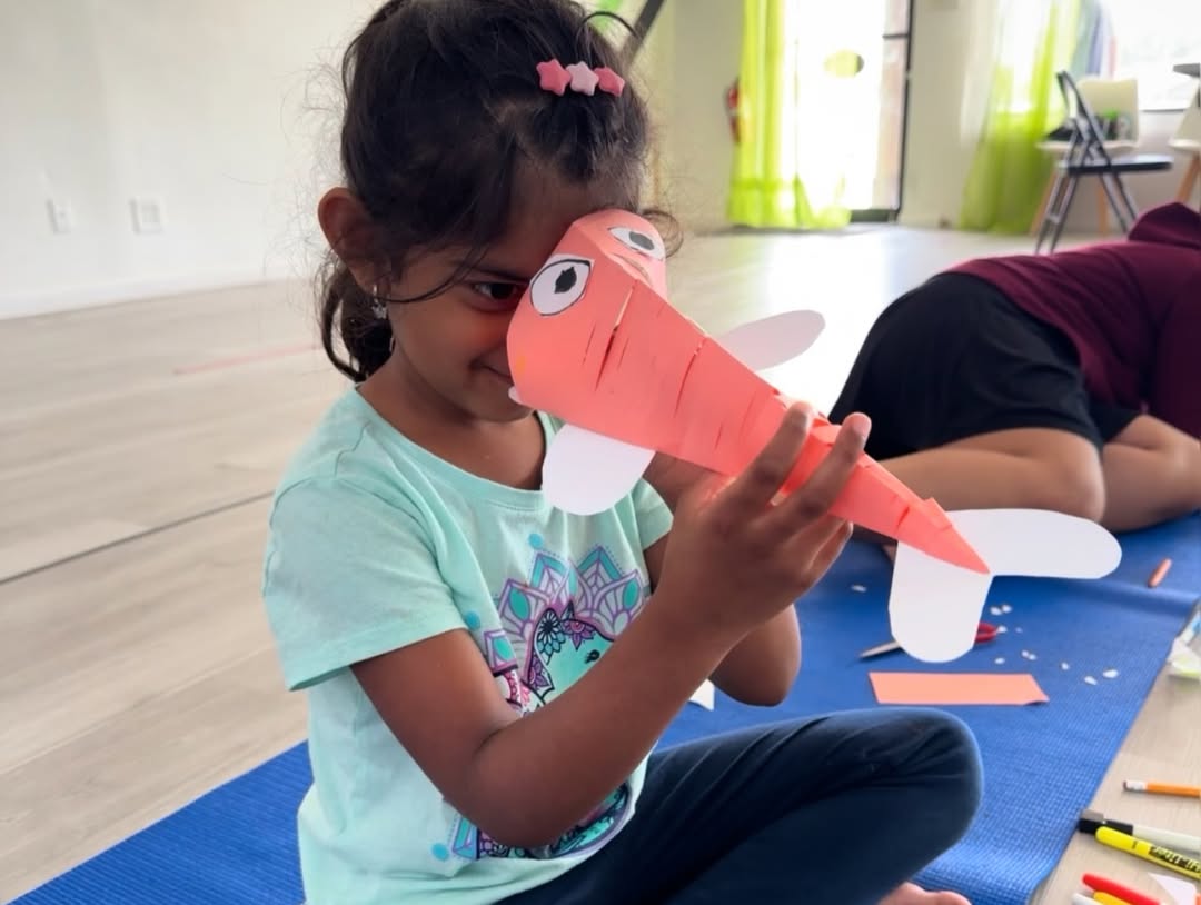 A summer camp child showing her craft project